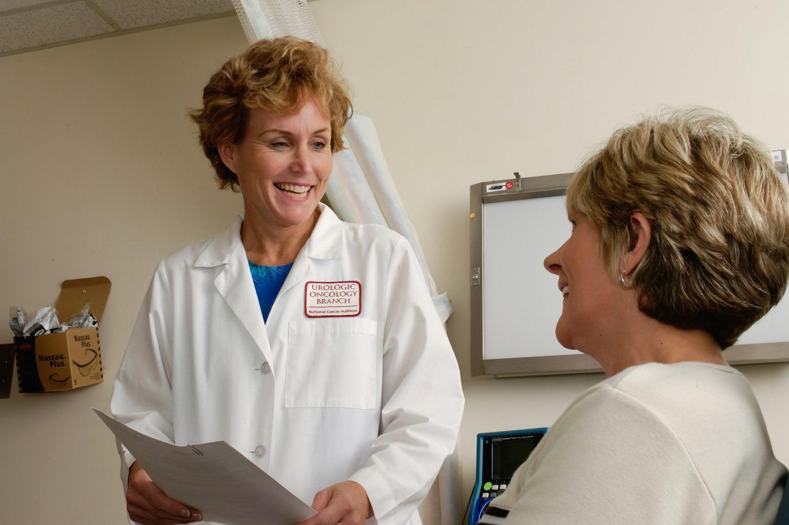 Senior compliance director reviewing customized safety binders with a practice manager in Physician Offices & Dental Clinics
